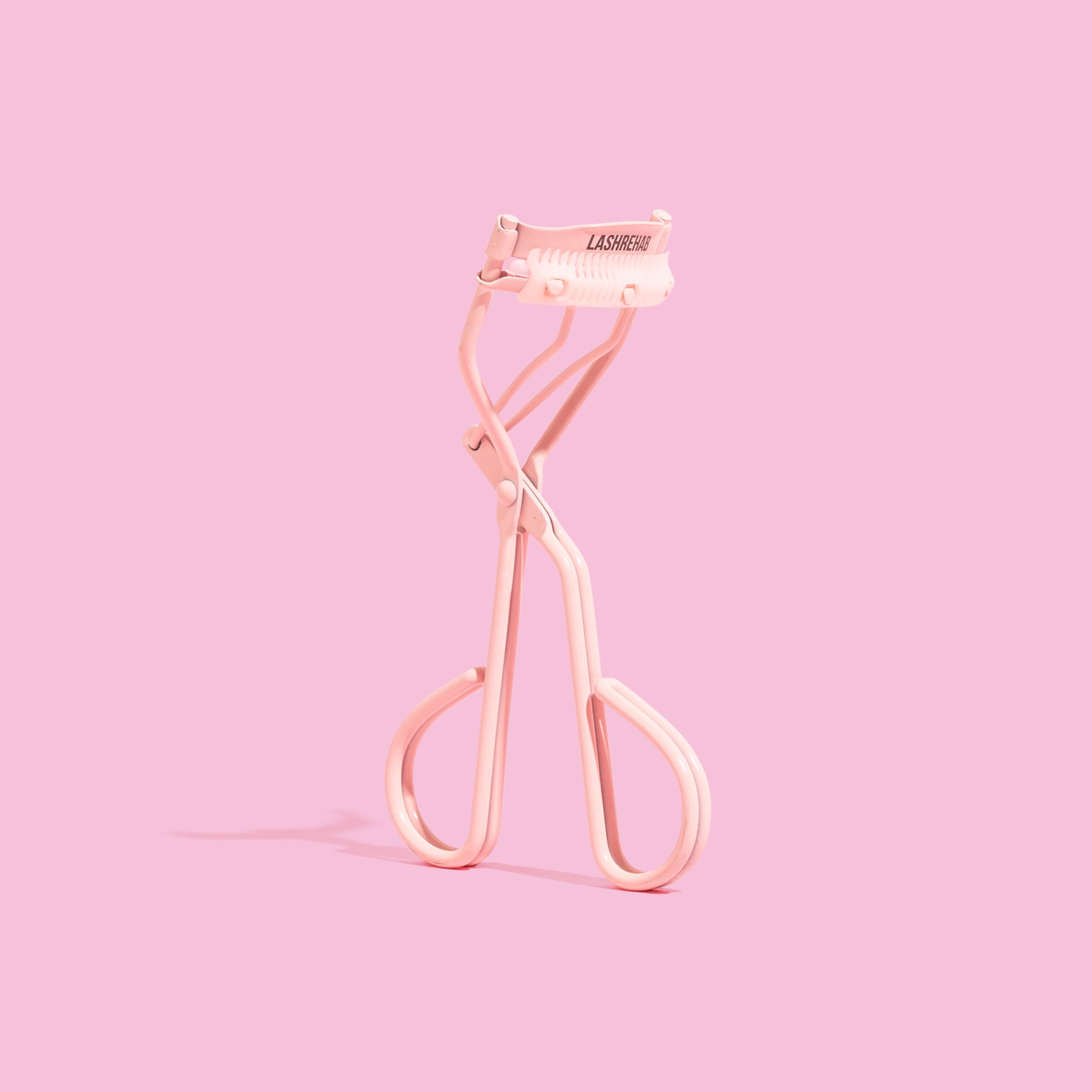 Lash Rehab Eyelash Curler - standing with pink background