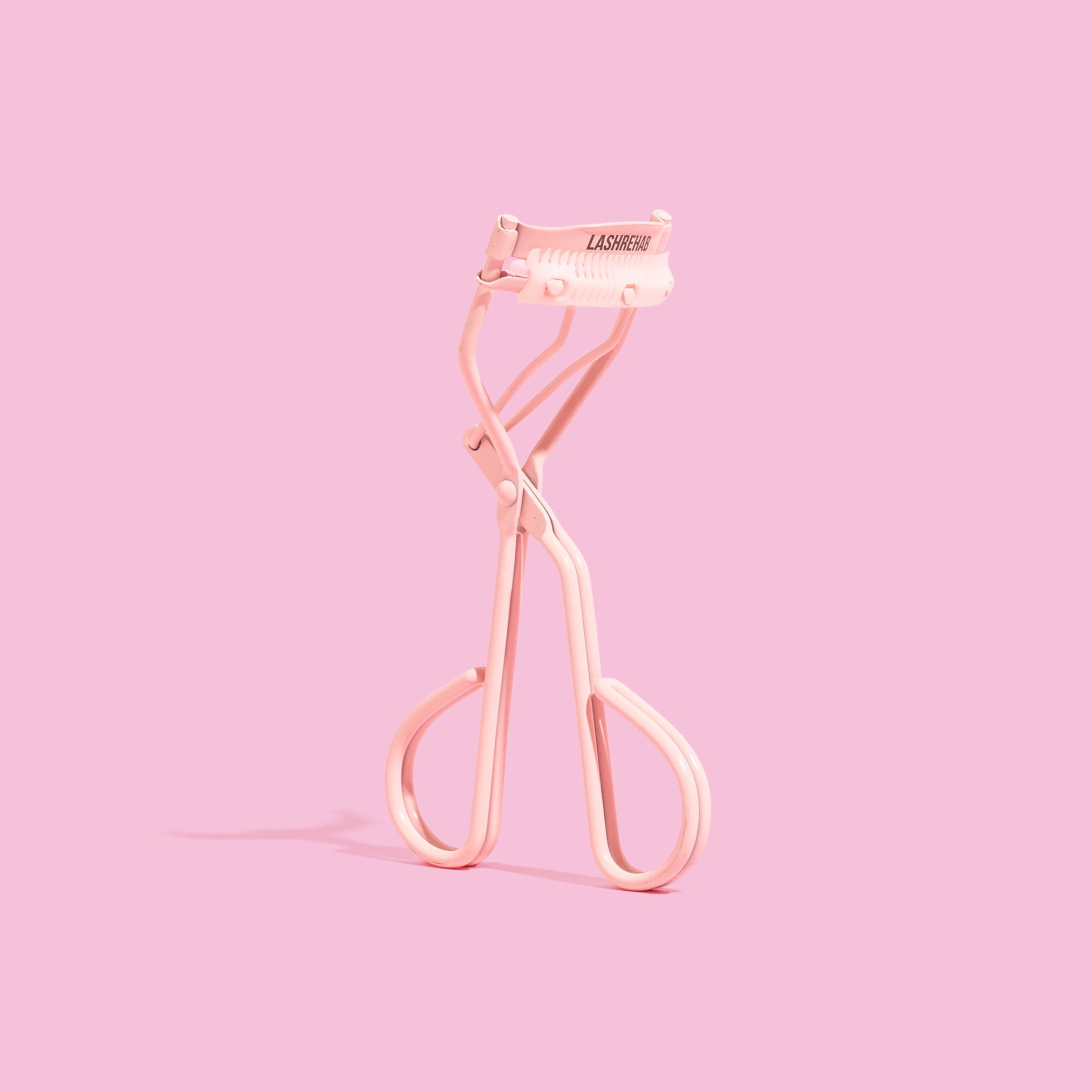 Lash Rehab Eyelash Curler - standing with pink background